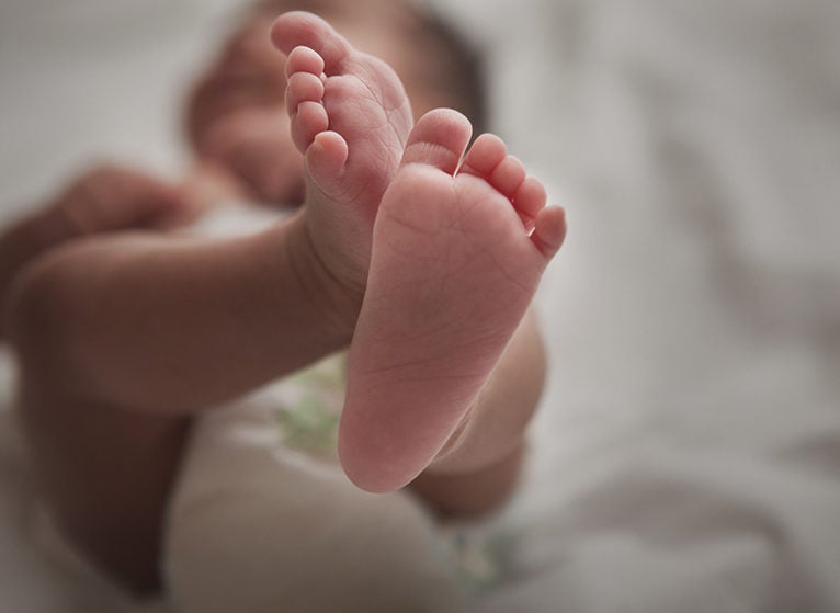 Close up of mixed race newborn baby girl's feet