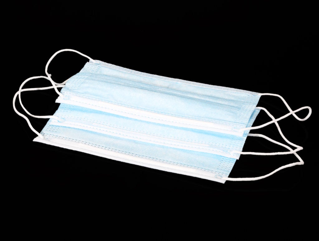 Medical protective face mask used on the face during the covid 19 pandemic to protect against coronavirus. Several masks isolated on a black background