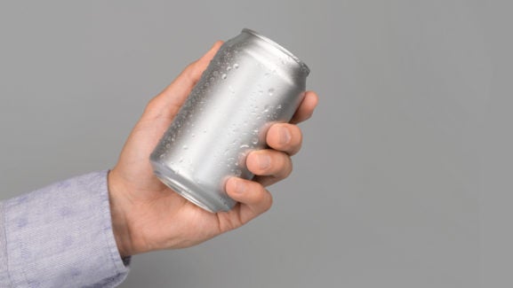 Hand holds metal beverage drink can