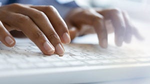 Hands of young woman typing on computer keyboard