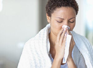 Sick woman blowing her nose