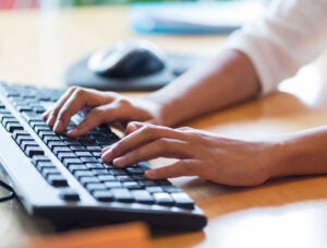 close up of female hands typing on keyboard