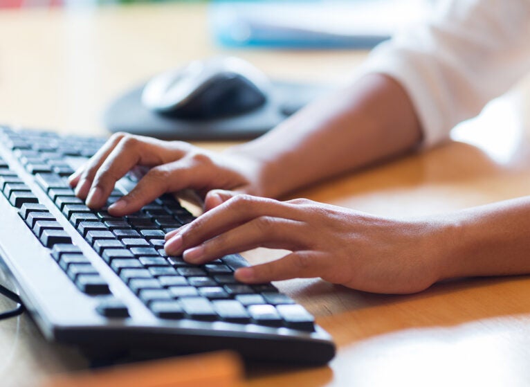 close up of female hands typing on keyboard