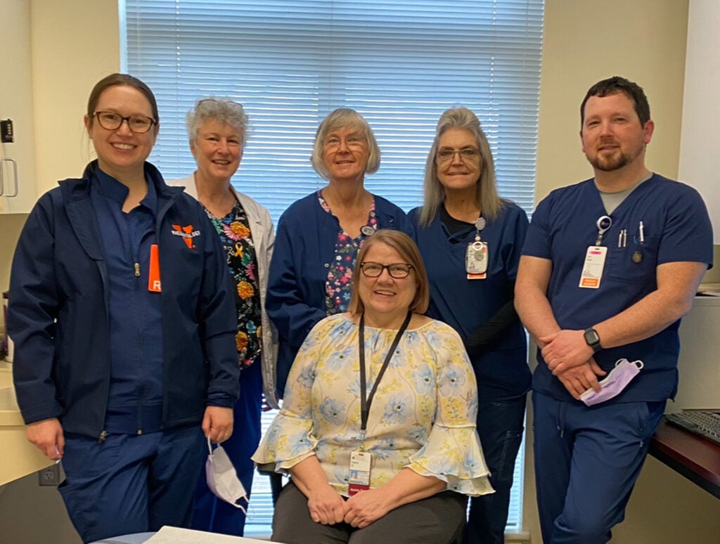 UVA Health Fontaine Research Park Rheumatology Clinic team members: (l-r) Standing left to right are Julie Mies, Cathy Kern, Suzanne Burge, Debra Mouberry, Jon Boyd, and (front, seated) Debra M. Williamson.