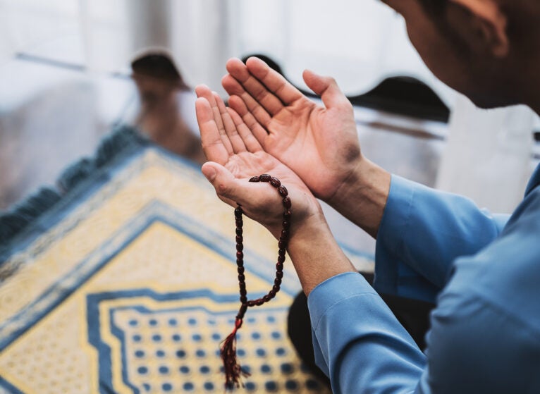 Muslim Man With Open Palm Praying at Home During Month of Ramadan