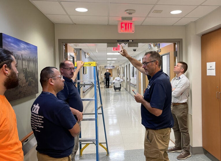 Mark Breeden, UVA Fire Protection Inspector and Ryan Dewyea, UVA Senior Project Planner review details of the upcoming fire alarm system upgrades with contractors.