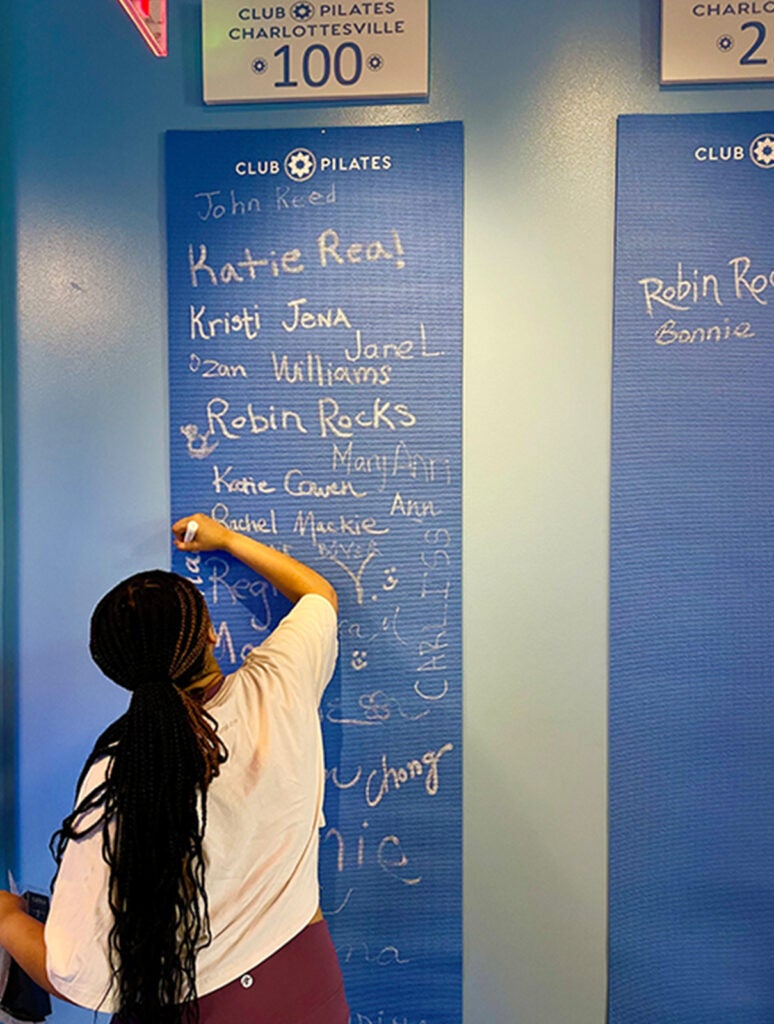 Shaolin signing the "100 classes" milestone board at Club Pilates. She has been doing Pilates since 2021, and it's become one of her favorite parts of her routine.