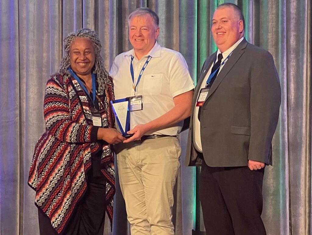 IDEA director Ivy Hinton (left) and simulation educator and faculty member James Nisley (right) traveled to St. Louis, MO, to receive the School's AAMN Award for 2024.