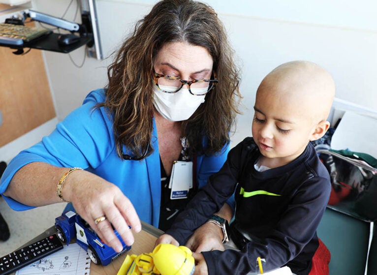 Murray, who works at UVA Children's pediatric oncology and hematology clinic, plays Legos during a visit with three-year-old oncology patient Lincoln Hines.