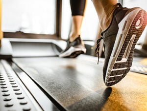 Close up of sole of sneakers of unrecognizable athlete jogging on a treadmill.