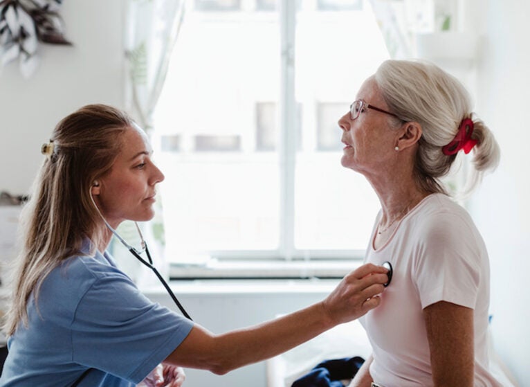 Side view of female doctor examining senior patient in medical clinic