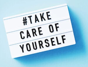 Take care of yourself written white lightbox sitting on blue background. Horizontal composition with copy space.