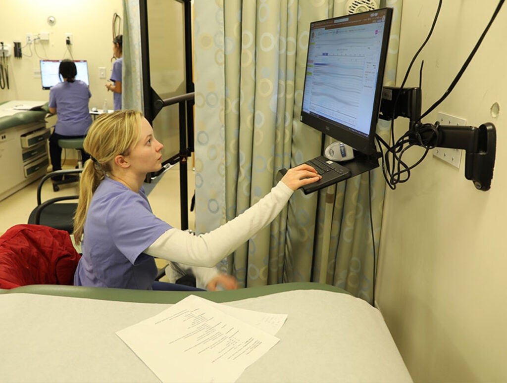 Later, students paired off to practice head-to-toe assessments and enter vital signs and assessment findings into their EHR flowsheets, getting real-time feedback from peers and faculty.