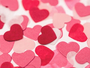 Lots of pink heart shaped paper confetti. Full frame for thank you or Valentine's Day card background. High angle view