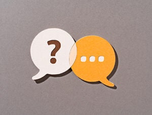 Paper Craft of Orange Color Question and Answer Speech Bubbles Overlapping on Brown Background Front View.