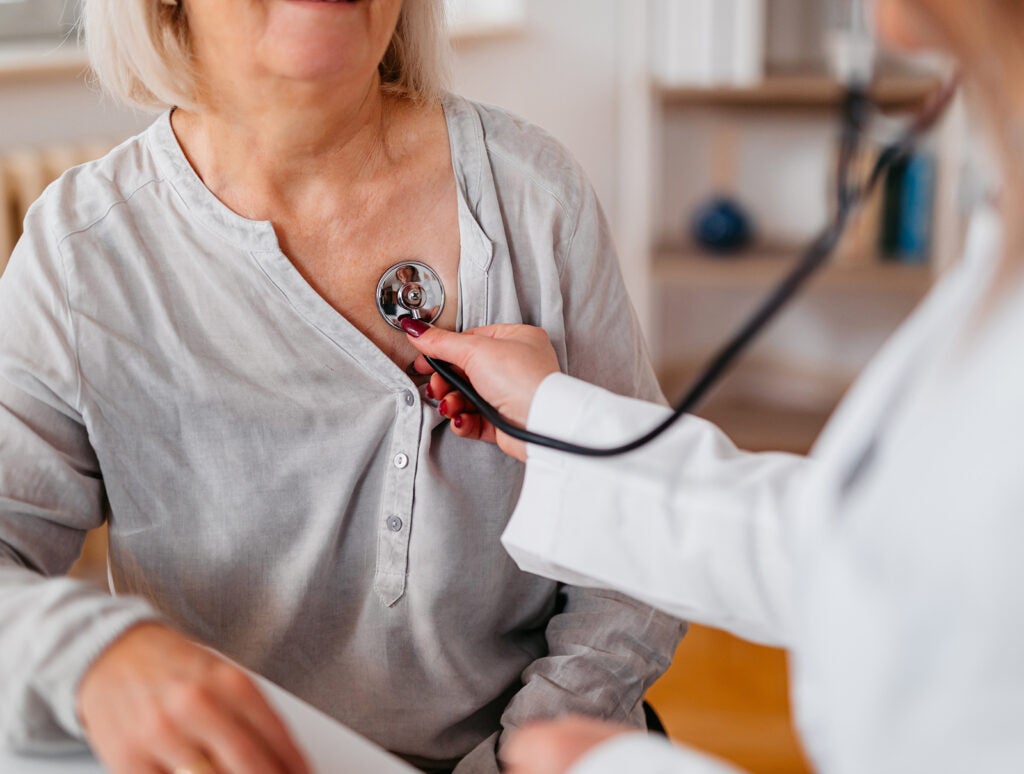 A close-up of a young female doctor auscultating a senior patient.