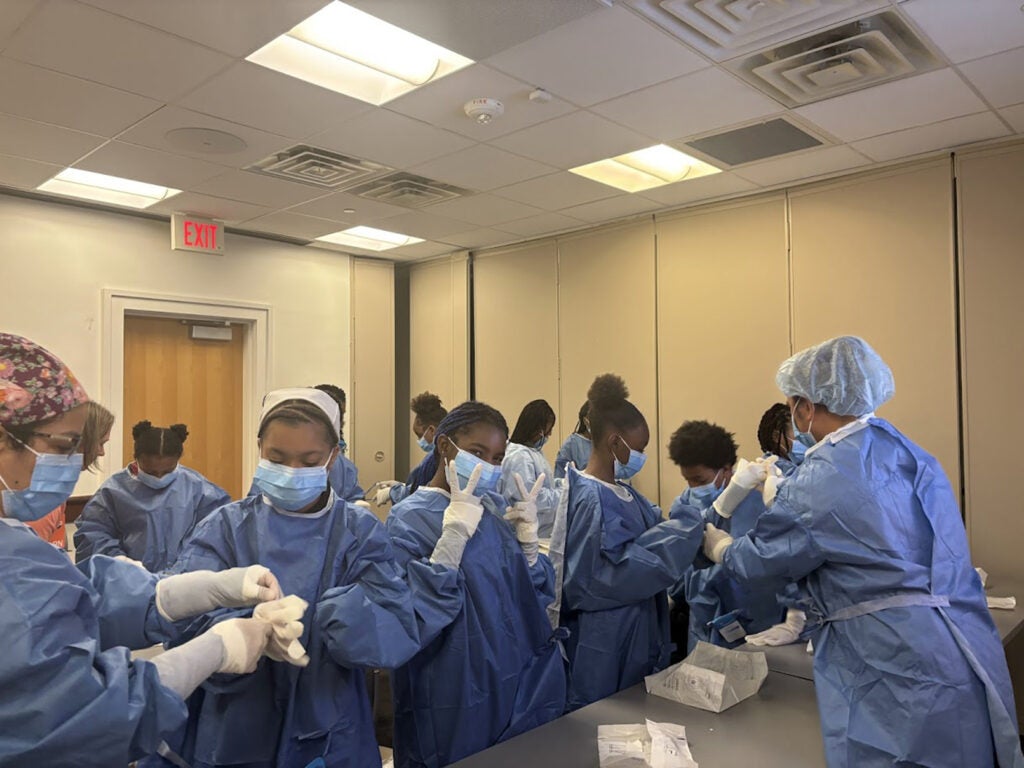 Students learning how to do donning and doffing.