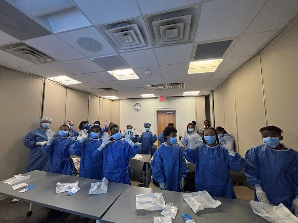 Students are all gowned up and ready for OR after a session with Billy Ray Carag, RN, Christa Mazur MSN, RN, CNOR, and Lilian Oseguera Rojas, RN