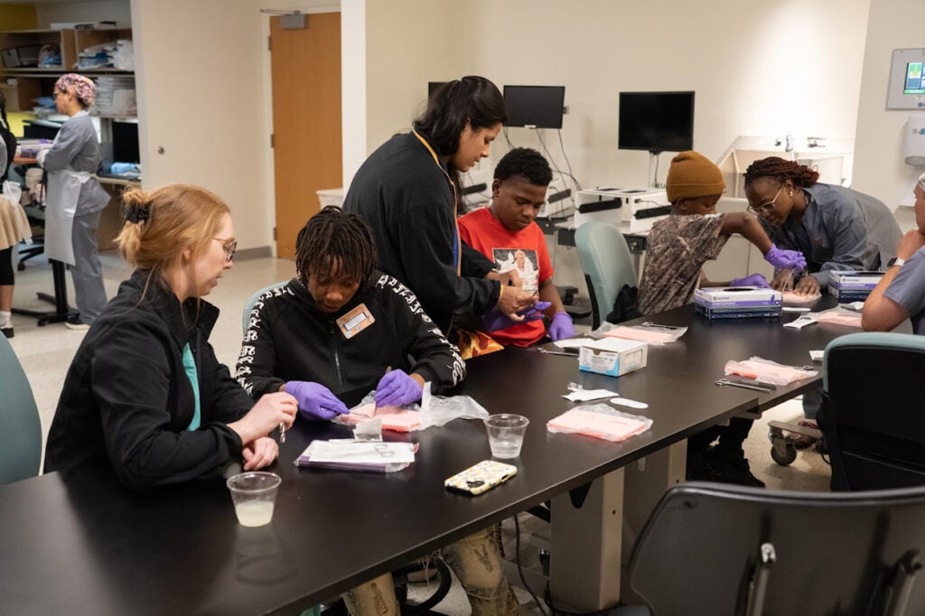 Faith Arimoro, MD, Amrita Sarkar, MD, and Olivia Sears, MD leading suturing station