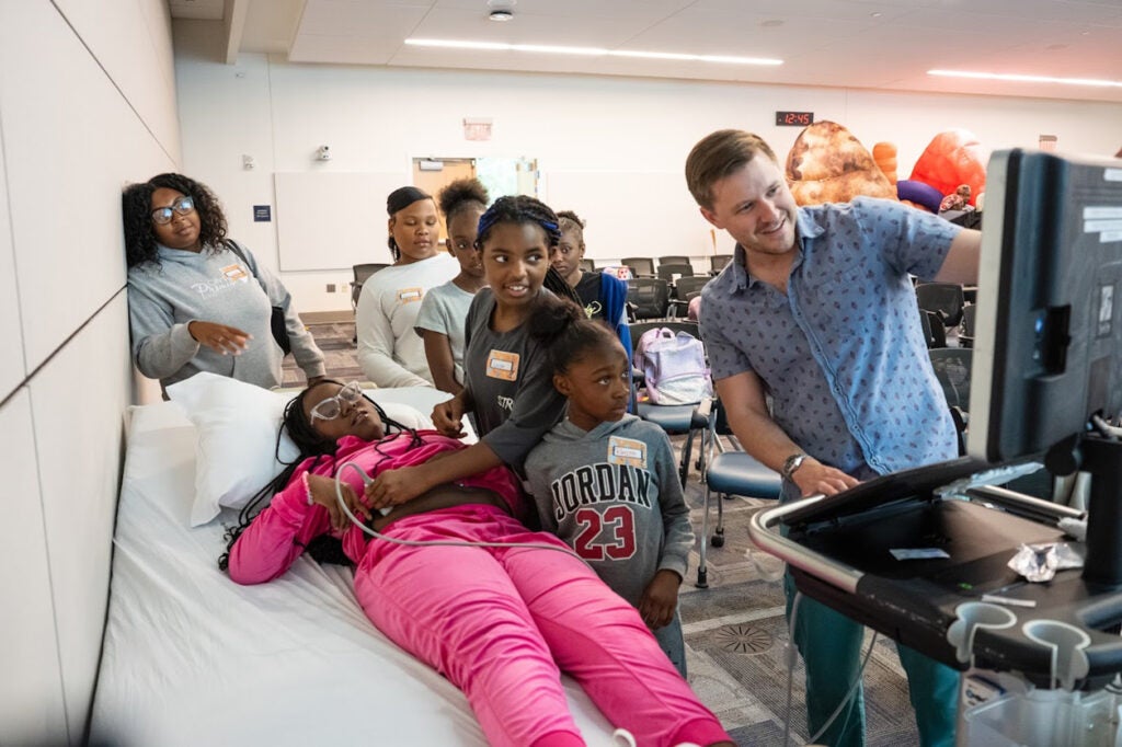 Sam Konkol, MD demoing the students use ultrasound