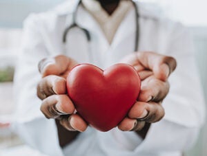Portrait of a doctor holding a heart in his hands