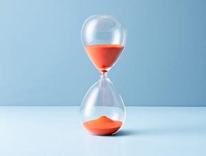 Orange Sand Hourglass on Light Blue Colored Background.