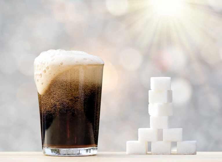 Glass of drink with cola with its equivalent sugar cubes, approximately 29 grams.
