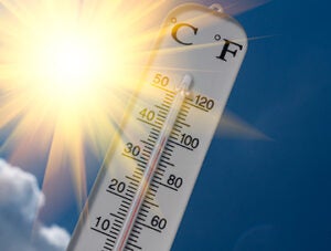 Thermometer against the sun and sky on a hot summer day